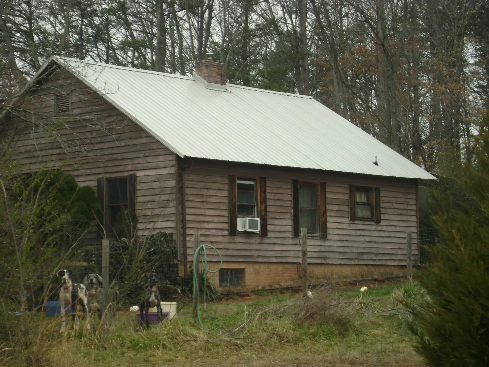 White metal roof on an old wood sided farmhouse, from a Metal Roof Installation job in Masonville